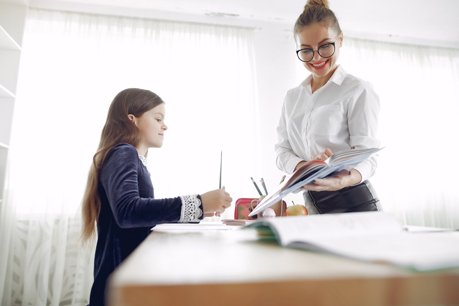 Qualified primary teacher supporting a pupil with schoolwork
